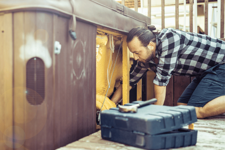 A young man setting an inflating hot tub