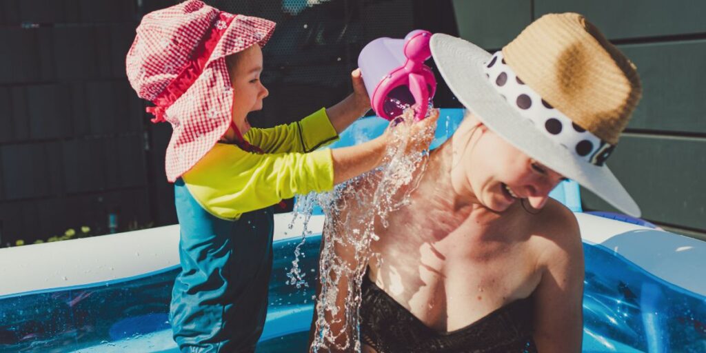 Baby Pouring Pool Water on Mother