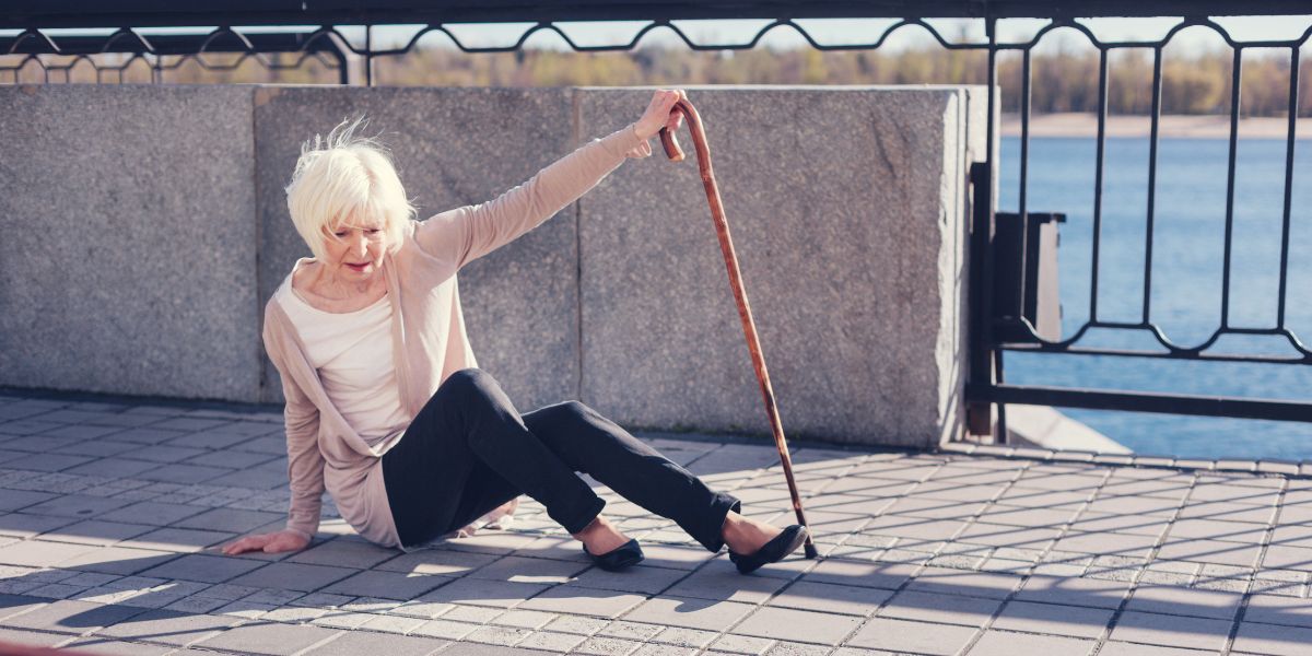 Elderly lady falling down in the street