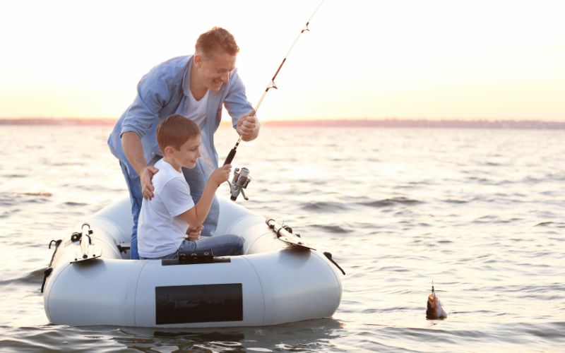 Father and son in an inflatable boat fishing