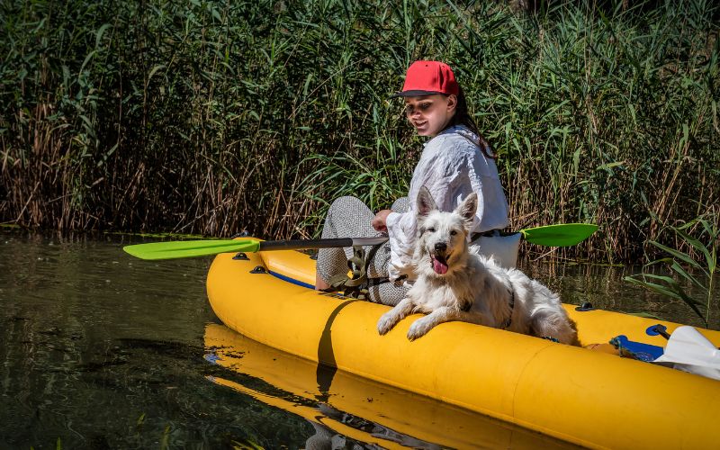 Girl and a dog in inflatable kayak