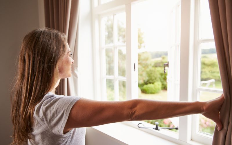 Woman Opening Curtains