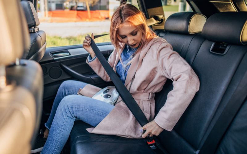 Woman putting on seat belt