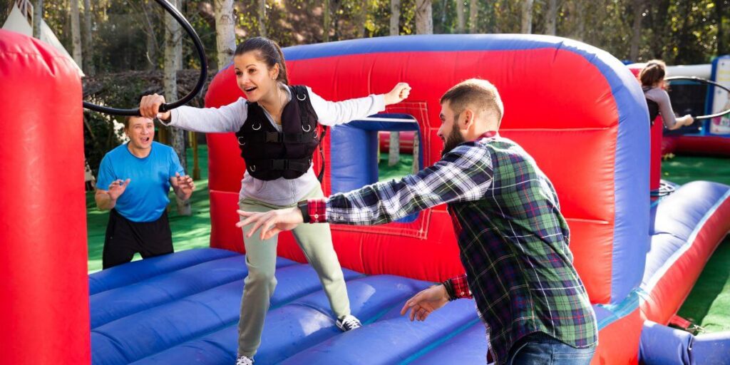 friends having fun passing inflatable obstacle course