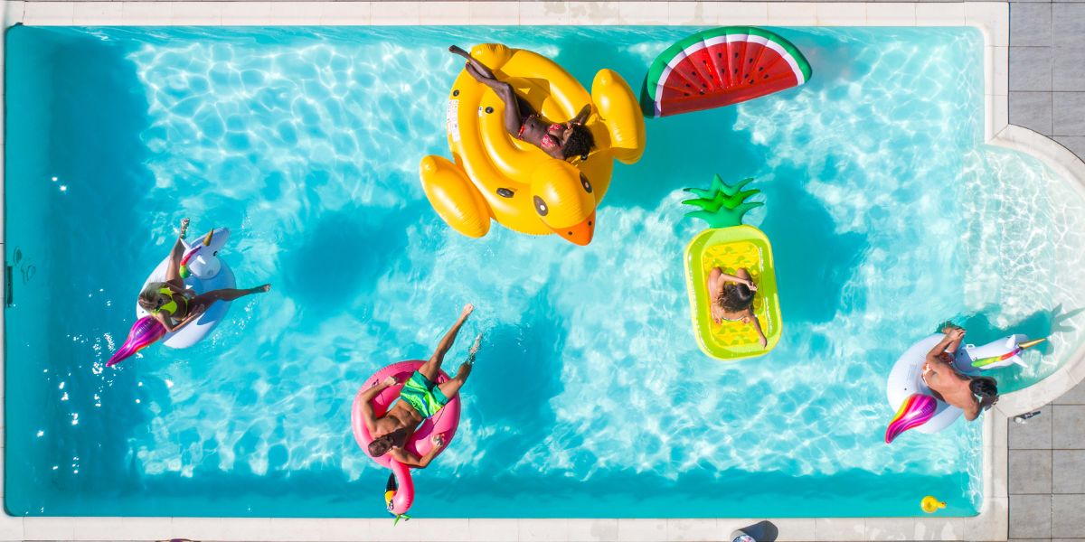 Friends having fun with their inflatables in the pool