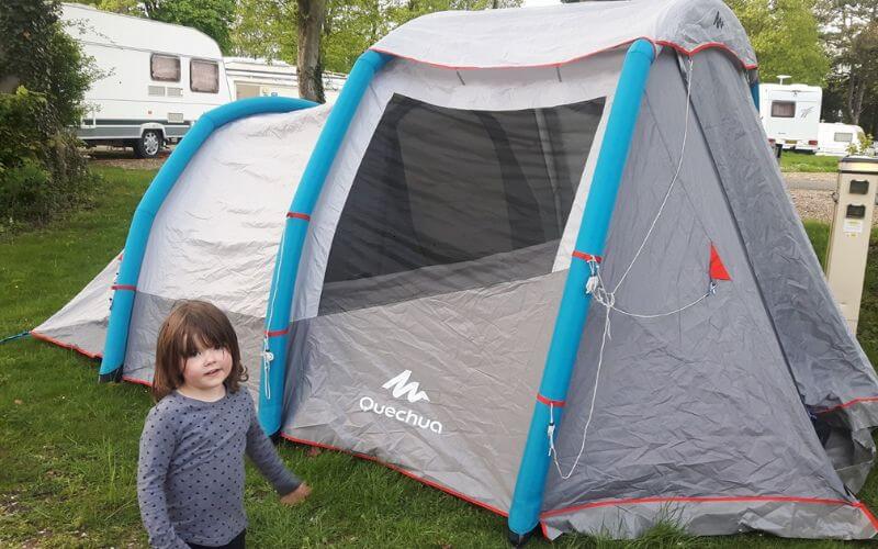 a young girl in front of an inflatable tent