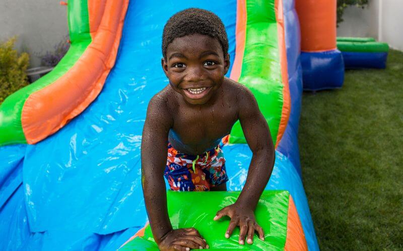 little boy sliding down an inflatable slide