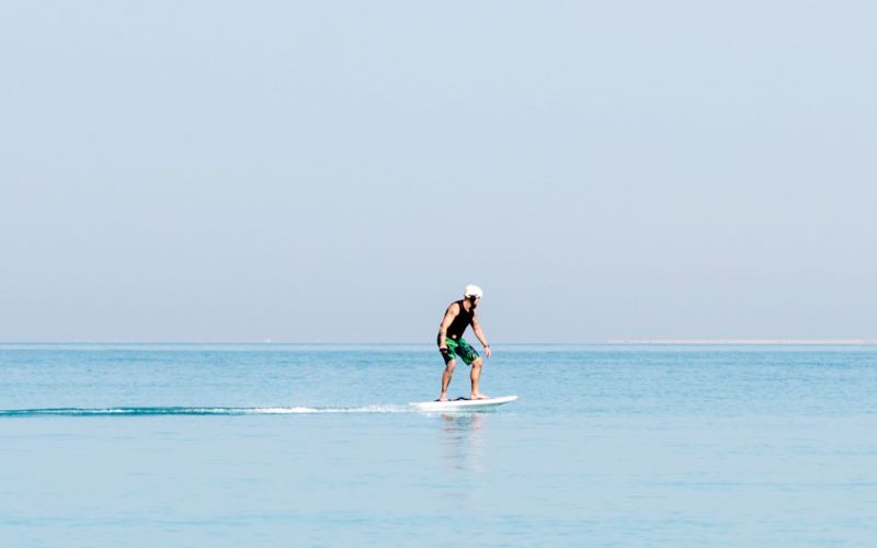 man trying out foil board in the beach