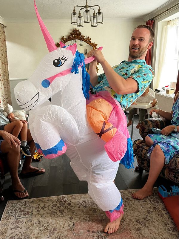 man wearing an inflatable unicorn costume
