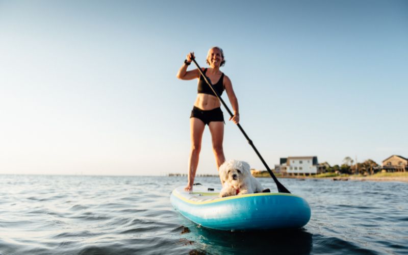 relaxing with dog on inflatable paddle board